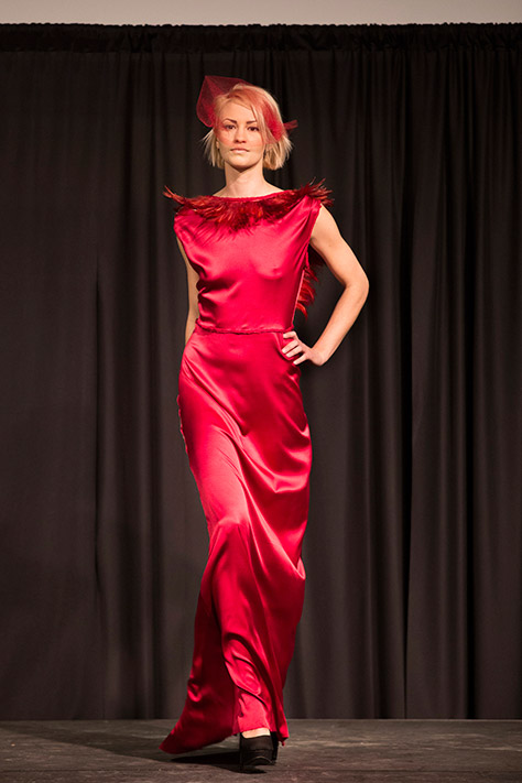 Female runway model in red dress at UW Fashion Week 2015.