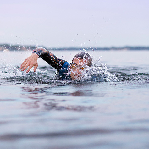 Action photo of a triathlete swimming in Lake Monona. 