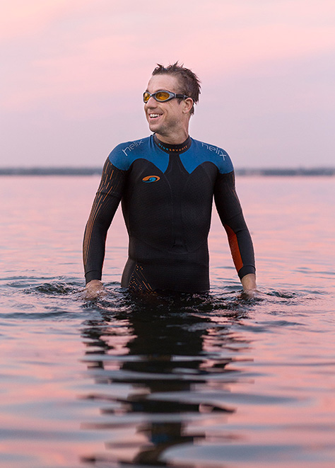 Editorial photo of a triathlete in Lake Monona at sunset. 