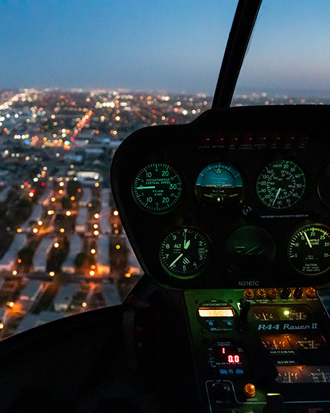 Helicopter cockpit flying over Los Angeles at night. 