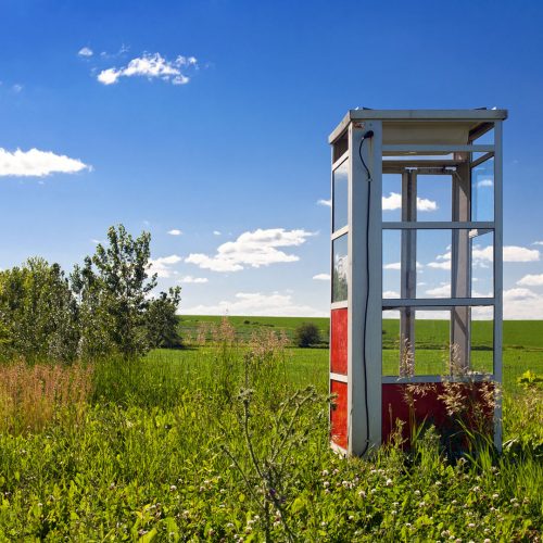 Abandoned phone booth in the field