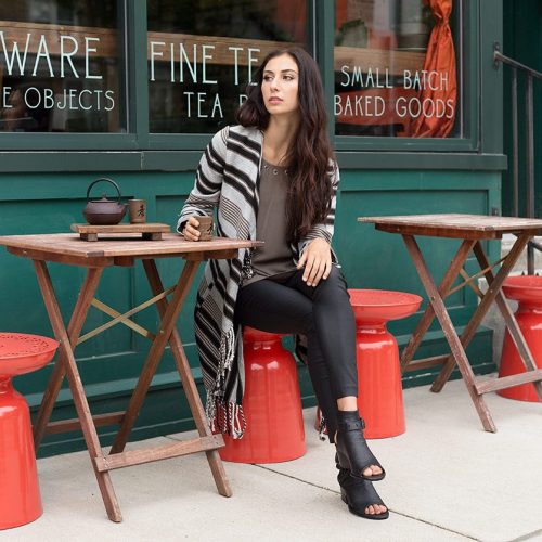 A woman sitting at an outdoor cafe having tea