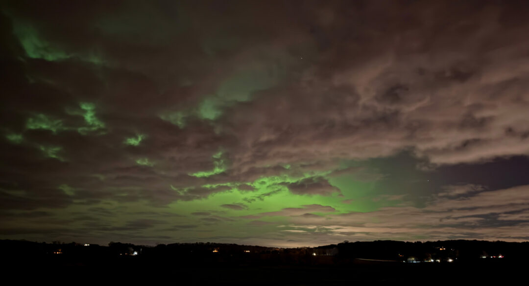 Green northern lights in clouds